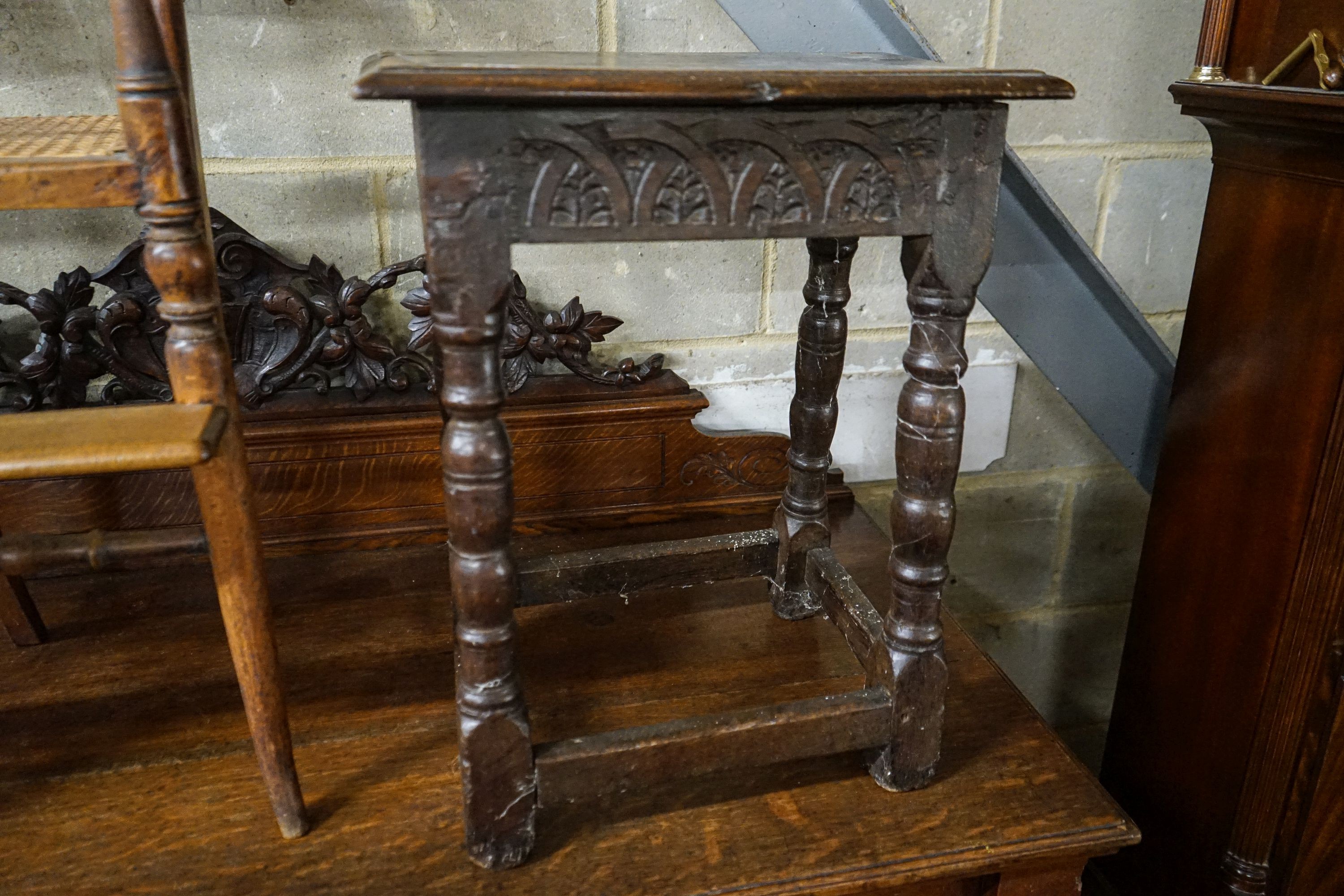 A 17th century style oak joint stool, with foliate carved frieze and turned legs, width 44cm, depth 28cm, height 56cm
